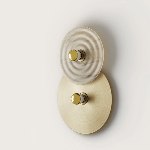 Wall lamp with stacked white marble ripple-patterned and brushed brass circular elements, each centered with a gold knob.
