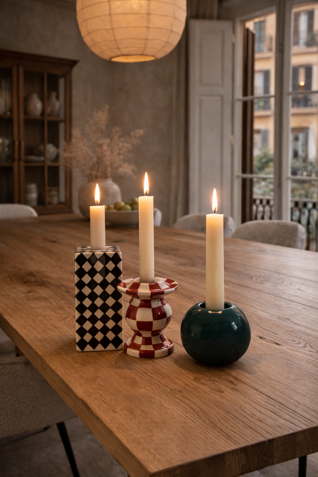 A set of three distinct candle holders from Les Objets Mouleversants: black and white checkered, red and white checkered, and dark teal.