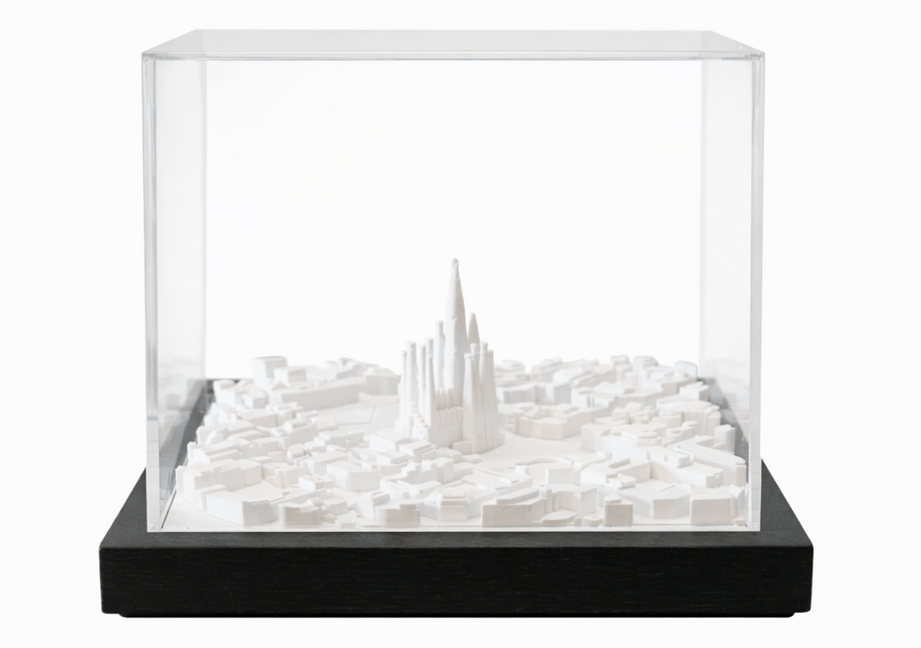 White cityscape art by Object and Story, featuring architectural models inside a transparent display case with a black base.