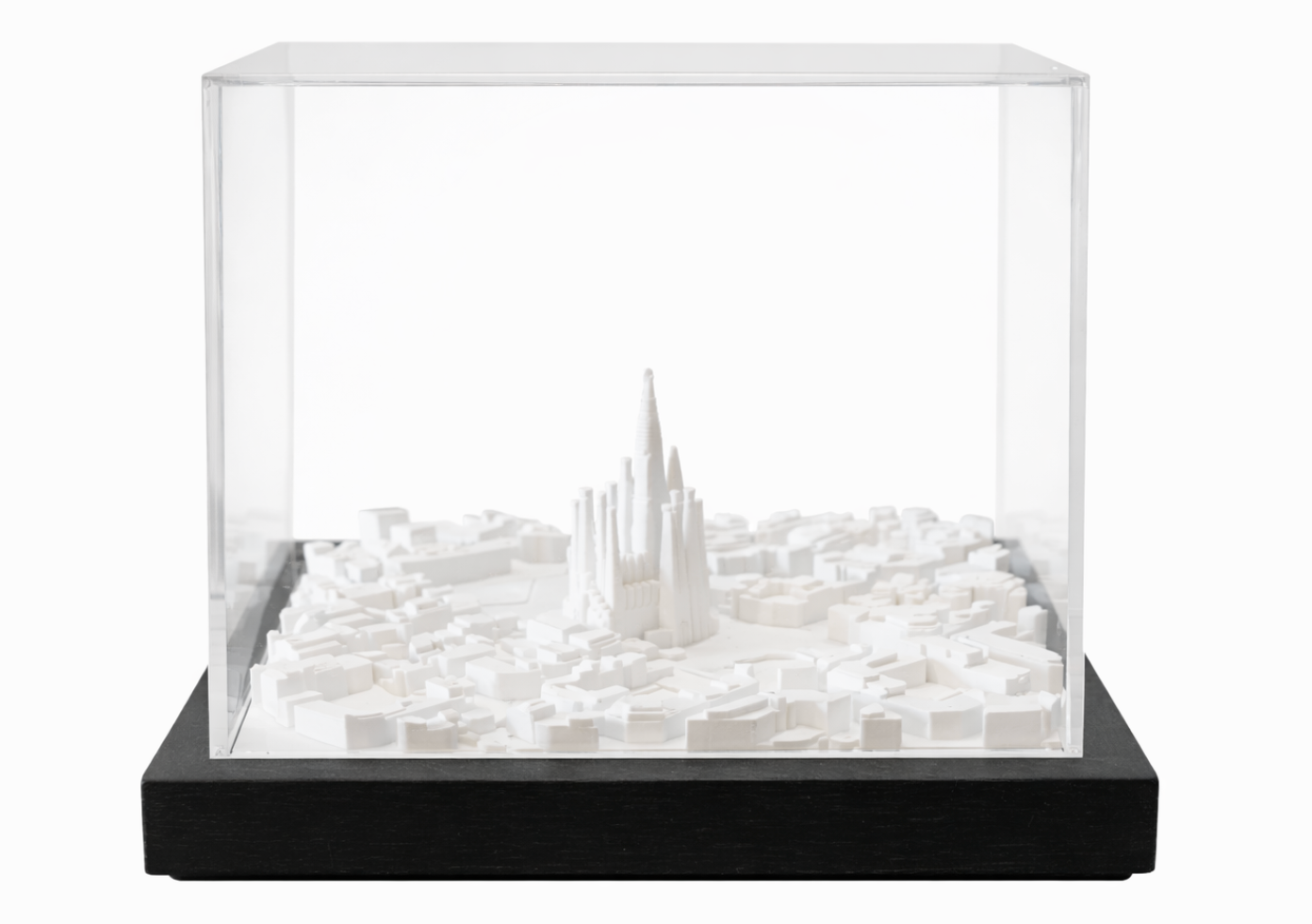 White cityscape art by Object and Story, featuring architectural models inside a transparent display case with a black base.