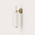 Modern brass wall sconce with ribbed glass shade, minimalist lighting for contemporary interiors