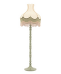 Sage green floor lamp with a two-tone, scalloped shade and long beige fringe, on a decorative turned base.