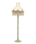Sage green floor lamp with a two-tone, scalloped shade and long beige fringe, on a decorative turned base.