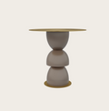Metric side table with a stacked sculptural taupe base and round gold metallic top and bottom accents.