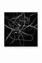 Black and white abstract art print featuring chaotic white strokes on a deep black background, presented at an angle.