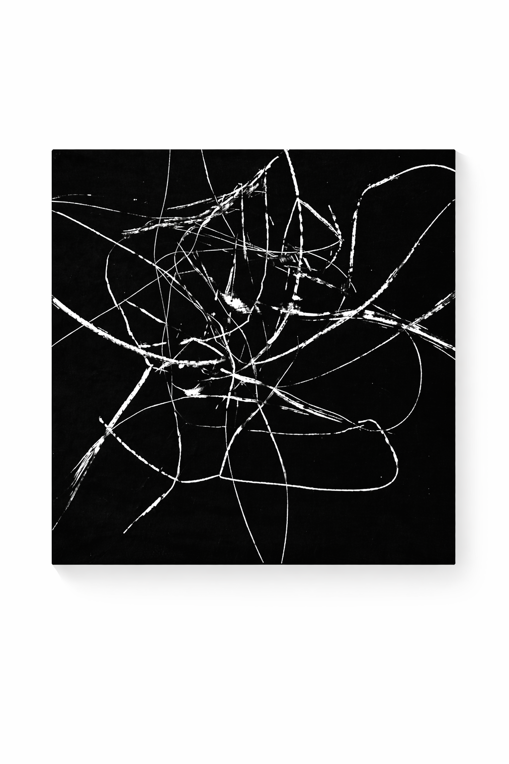 Black and white abstract art print featuring chaotic white strokes on a deep black background, presented at an angle.