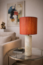 Terracotta textured table lamp by Mondarin with a cylindrical marbled base, styled on a glass side table.