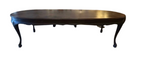 Dark brown polished wood oval table with carved apron and cabriole legs.