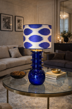 Provet Lamp with a cobalt blue spiked glass base and white and blue ikat patterned shade on a coffee table.