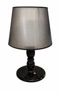 Black table lamp with a dark, translucent lampshade and a glossy, turned black base.