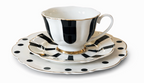 A layered black and white striped tea cup and saucer set with gold trim and a polka-dotted bottom plate.