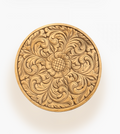 Round wood tray with intricate floral and scrollwork carving, in a natural wood tone on a white background.