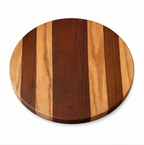 Round wood board by JS with alternating dark and light brown vertical strips, embossed with 'JS' monogram.