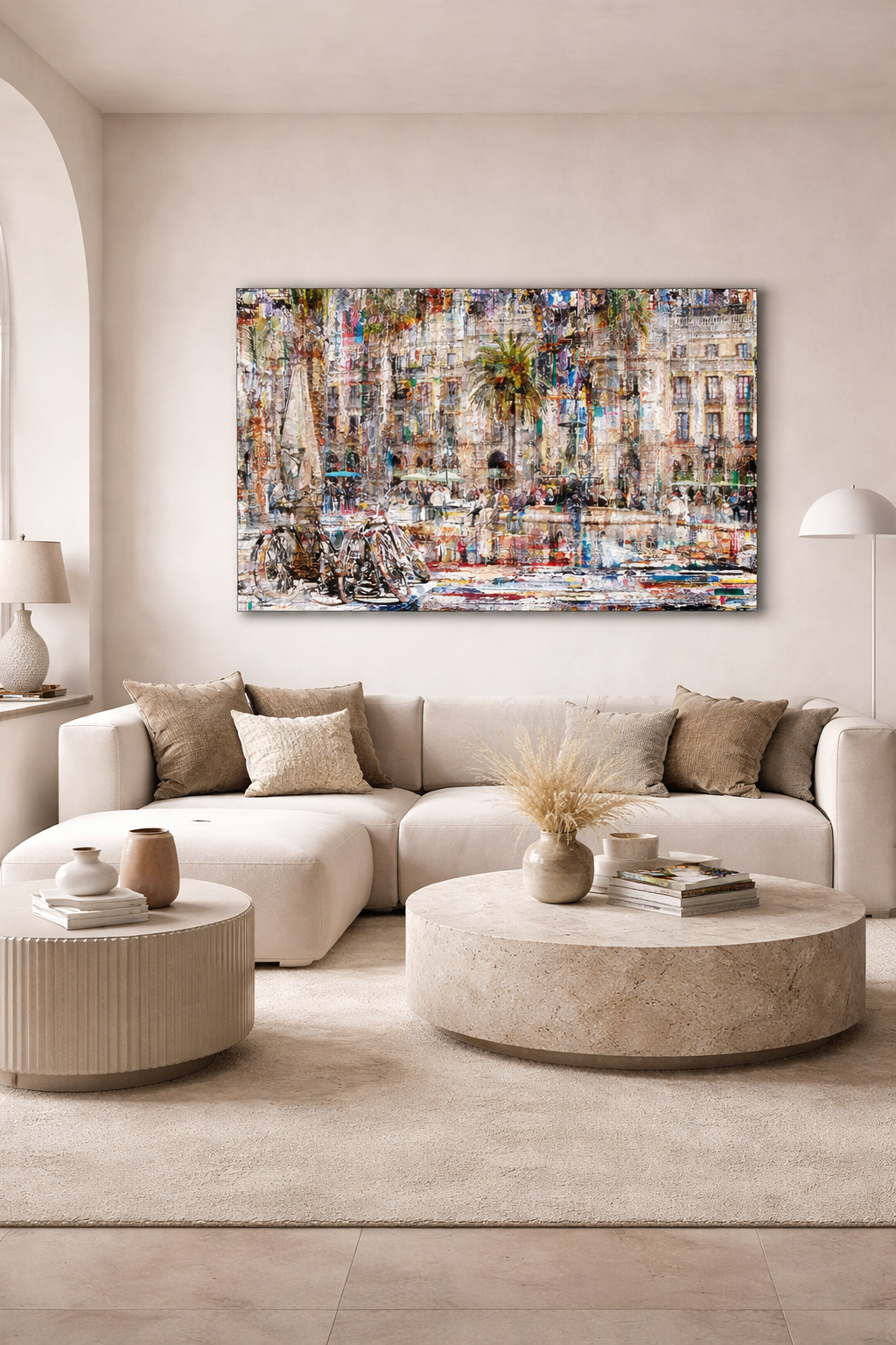 Vibrant abstract painting of a Barcelona street scene with buildings, a palm tree, and bicycles, hung above a cream sofa.