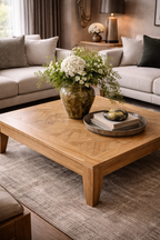 Damas coffee table in light natural wood with a geometric patterned top and tapered legs, styled in a living room.
