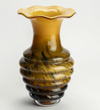 Honey-colored glass vase with a ruffled rim, ribbed body, and dark swirling patterns, fading to black.