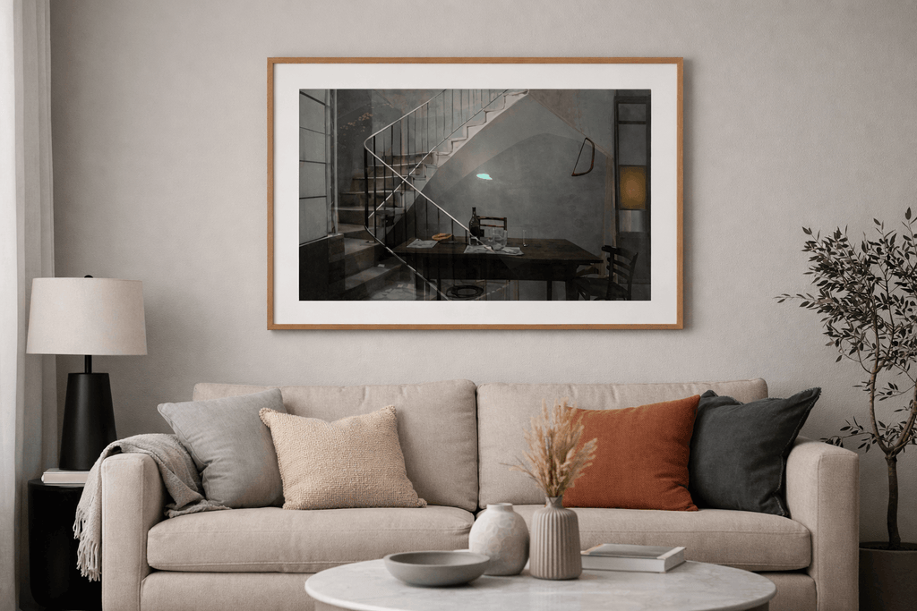Desván painting by Manuel Cohen depicting an interior staircase scene, framed in light wood, in a modern living room.