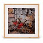 Framed painting by Manuel Cohen depicting a layered urban destruction scene with rubble and vivid red fabric.