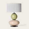 White pleated table lamp with stacked pale green and pink glossy spherical bases.