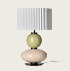 White pleated table lamp with stacked pale green and pink glossy spherical bases.
