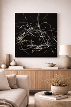 Moonlight Drizzle painting, a black and white abstract artwork with white scribbled lines, in a modern living room setting.