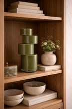 Pila Moss Green Vase featuring a glossy, stacked cylindrical design displayed on a wooden shelf.