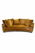 Ocre Sofa with a curved design, featuring plush velvet-like fabric, multiple loose cushions, and short wooden legs.