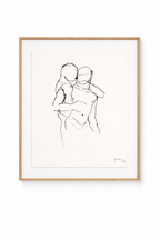 A framed people painting featuring a minimalist black line drawing of two embracing figures with an artist's signature, in a light wooden frame with a white mat.
