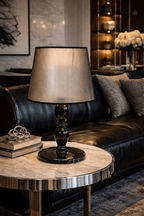 Pessoa Table Lamp with a light gold tapered shade and a dark, glossy double-gourd base on a marble side table.