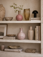 Tall amber glass Petal Vase with a fluted texture and wavy rim, styled on a neutral shelf.