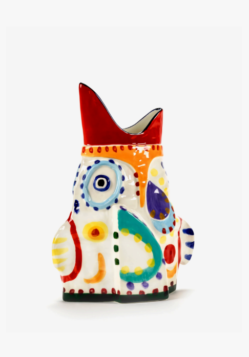 White ceramic vase with a red peaked top and multi-colored abstract patterns.