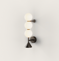 Dark metal wall lamp with three glowing white spherical globes and a black marble conical base, mounted vertically.